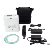 A portable oxygen concentrator kit laid out on a white background, including a white concentrator unit, black carrying case, tubing, power adapters, and a black strap with a yellow band.