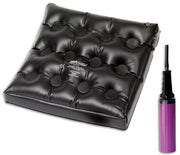 Black inflatable cushion with air pump on a white background