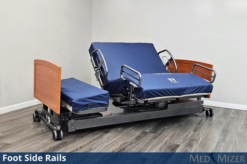 Electric hospital bed with foot side rails on a wooden floor, featuring Med Mizer branding.