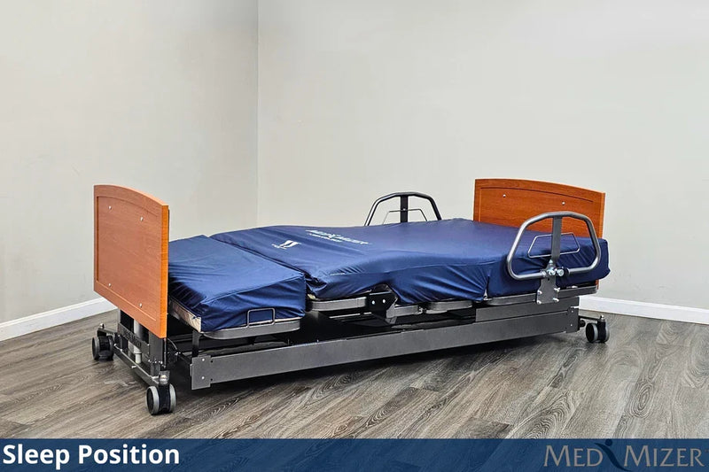 Elevated hospital bed with wooden headboard and footboard on a wooden floor.