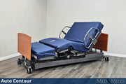 Electric adjustable bed with blue cover on a wooden floor, featuring 'Auto Contour' and 'Med Mizer' branding.