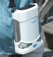 Portable concentrator device attached to a person's waist with a blurred background