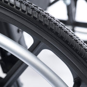 Close-up of a bicycle tire with tread pattern and metal rim.