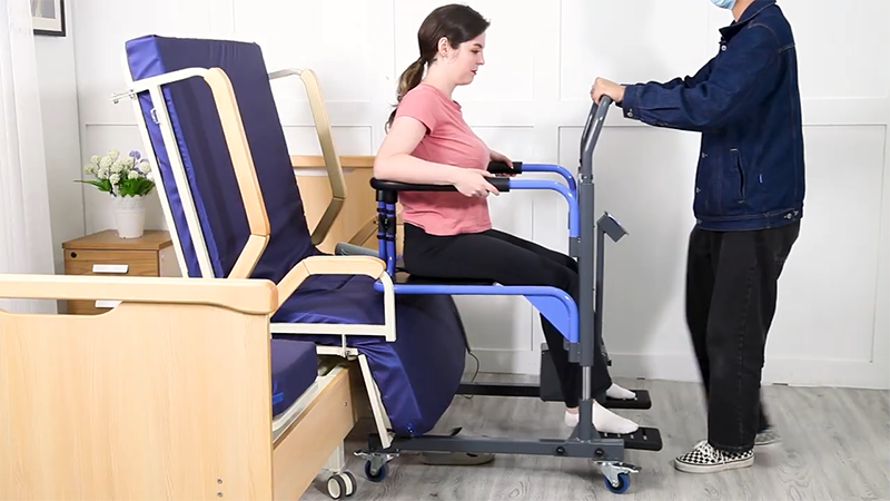 Person using a transfer board to help another person into a chair.