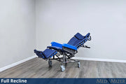 Blue reclining medical chair on a wooden floor with a white wall background