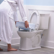 Person using a step stool to reach the top of a toilet in a bathroom setting.