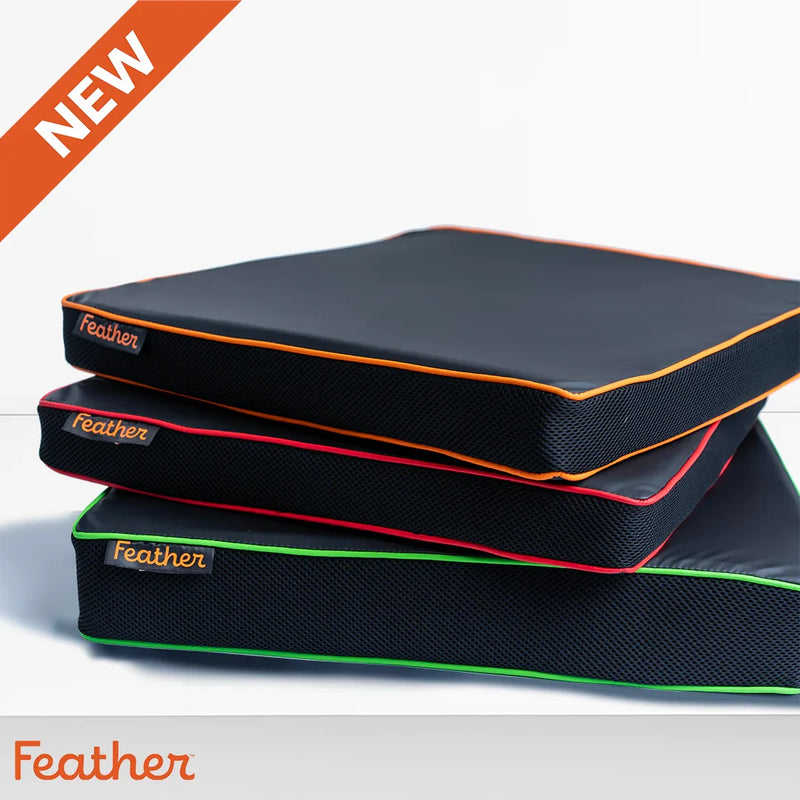 Stack of Feather brand seat toppers with color accents on a gray background