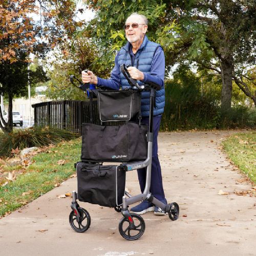 Man using a rollator with bags on a sidewalk