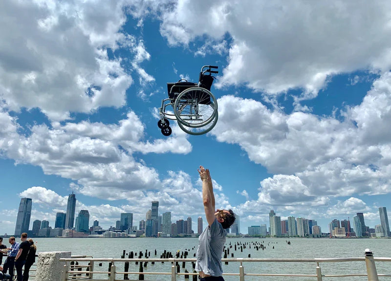 man throwing wheelchair into the air