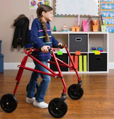 Child using a red walker in a classroom setting