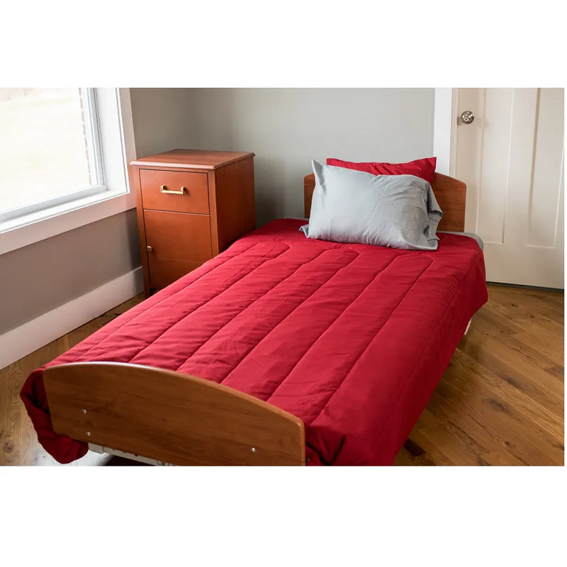 Bed with red bedding and wooden headboard in a room with a window and dresser.