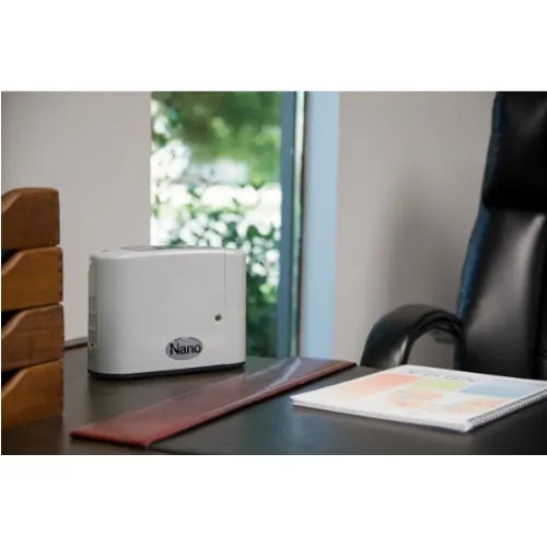 Nanoe device on a desk with a chair and window in the background
