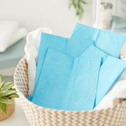 Blue napkins in a woven basket with a blurred indoor background