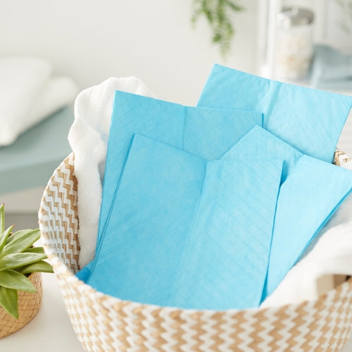 Blue napkins in a woven basket with a blurred indoor background