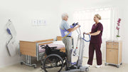 Physiotherapist assisting a patient using a treadmill in a hospital room.