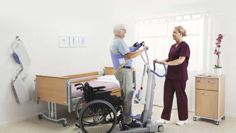 Physiotherapist assisting a patient using a treadmill in a hospital room.