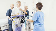 nurses helping a client stand using a lift