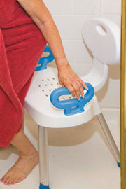 Person using a white stool with blue handles in a bathroom setting