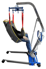 A motorized patient lift chair with a gray and black sling seat, red straps, and a blue base, shown with a mannequin or person seated inside on a white background.