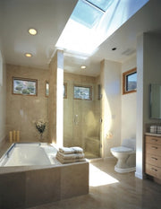 Modern bathroom with a skylight, bathtub, and toilet.
