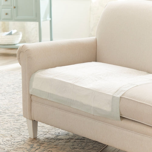 Beige sofa with a transparent pet barrier on a wooden floor in a living room.