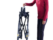 Person holding a black folding bike on a white background