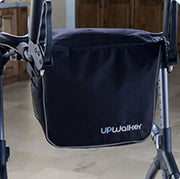 Black bag with 'UPWalker' logo attached to a walker on a wooden floor.