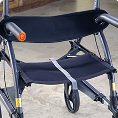 Close-up of a wheelchair with a folded seat on a concrete surface