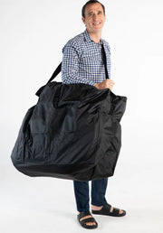 Man holding a large black bag against a white background
